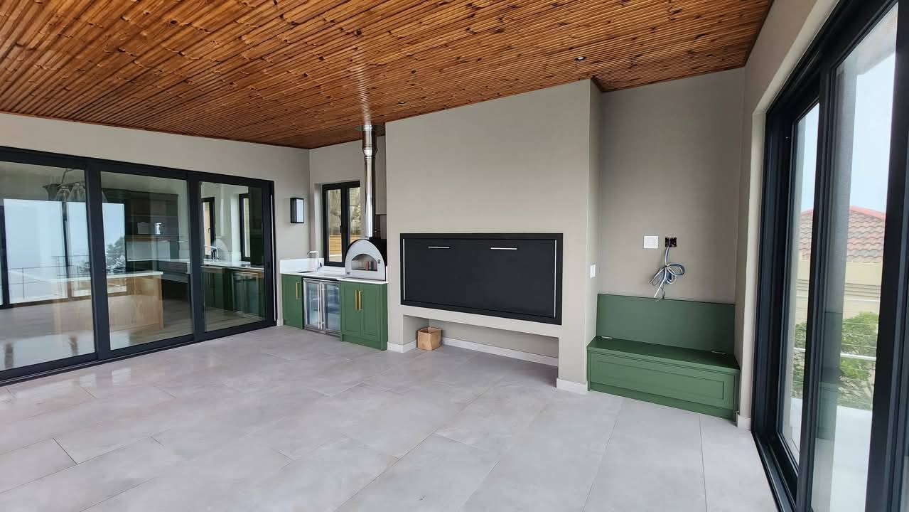 Covered outdoor kitchen with timber ceiling, pizza oven and built-in braai