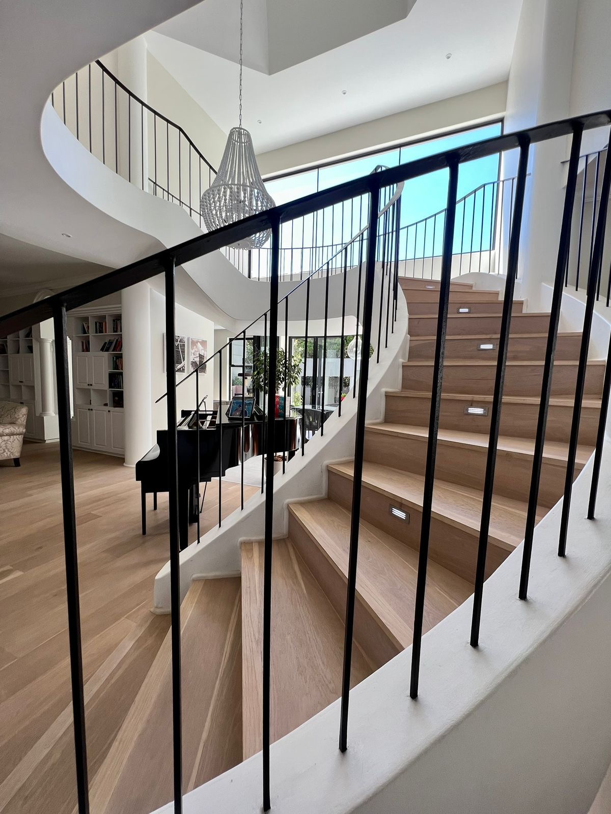 Finished curved staircase with timber treads and slim steel balustrades